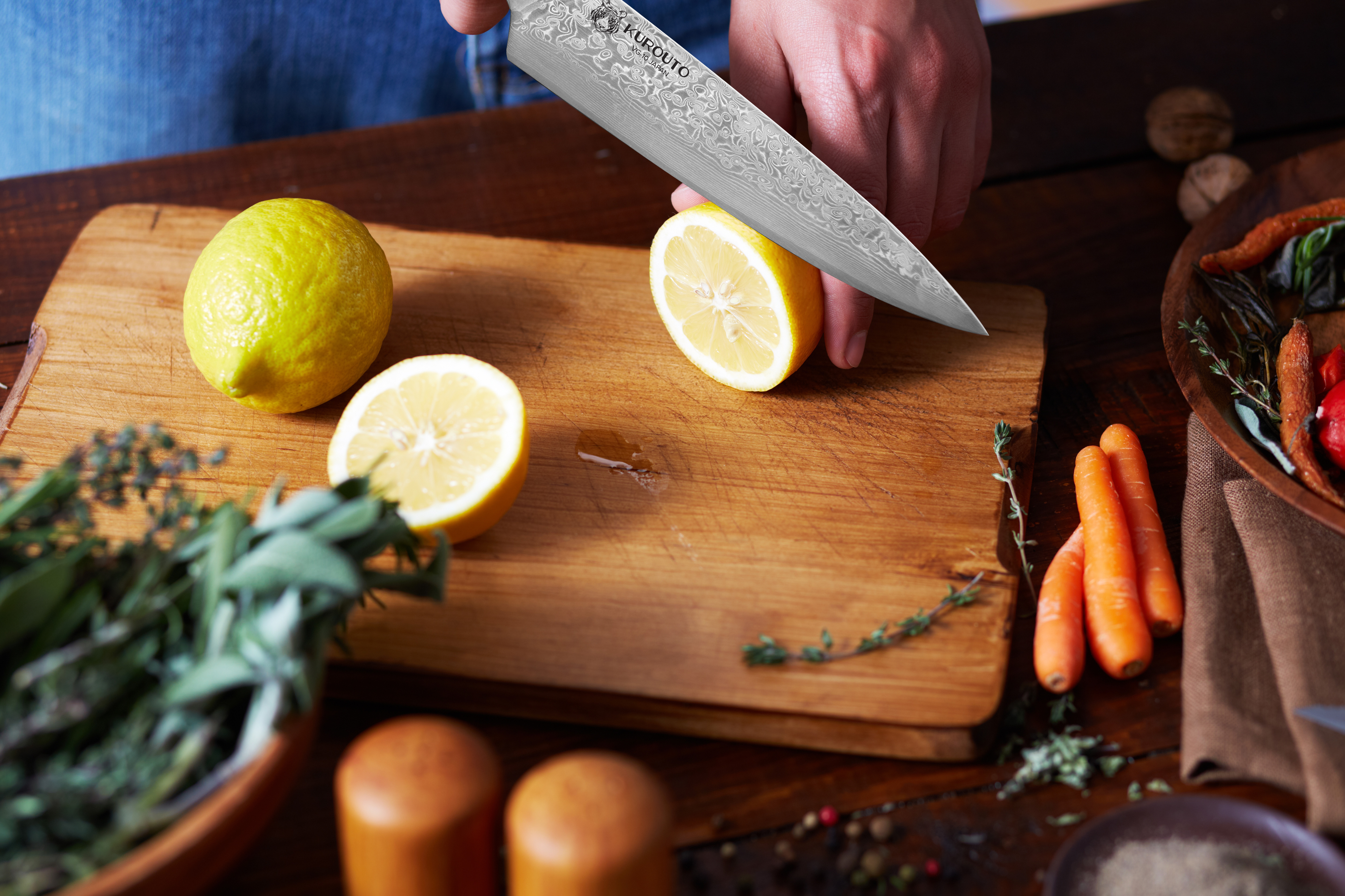 Kurouto Kitchenware Chef's Knife Slicing a Ripe Lemon on a Wooden Cutting Board